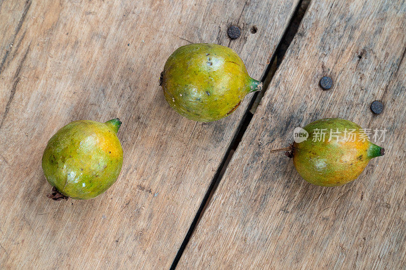 特写的异国水果Grugru坚果“澳门”“Acrocomia aculeata”木质背景。来自巴西本土的一种棕榈树被用作食物，其油用于生产生物柴油。